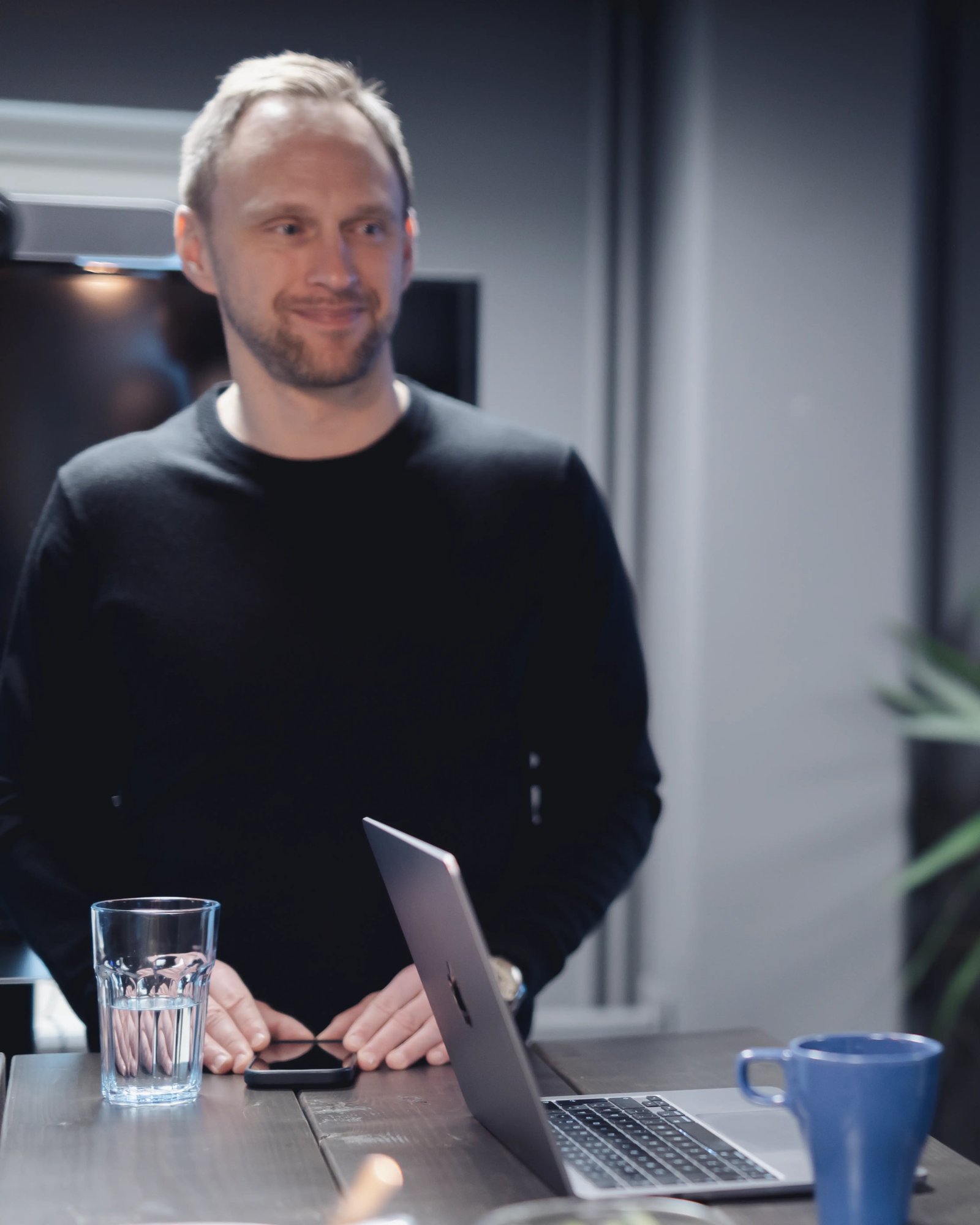 A picture of Andrej standing at a table in the TeQflo office