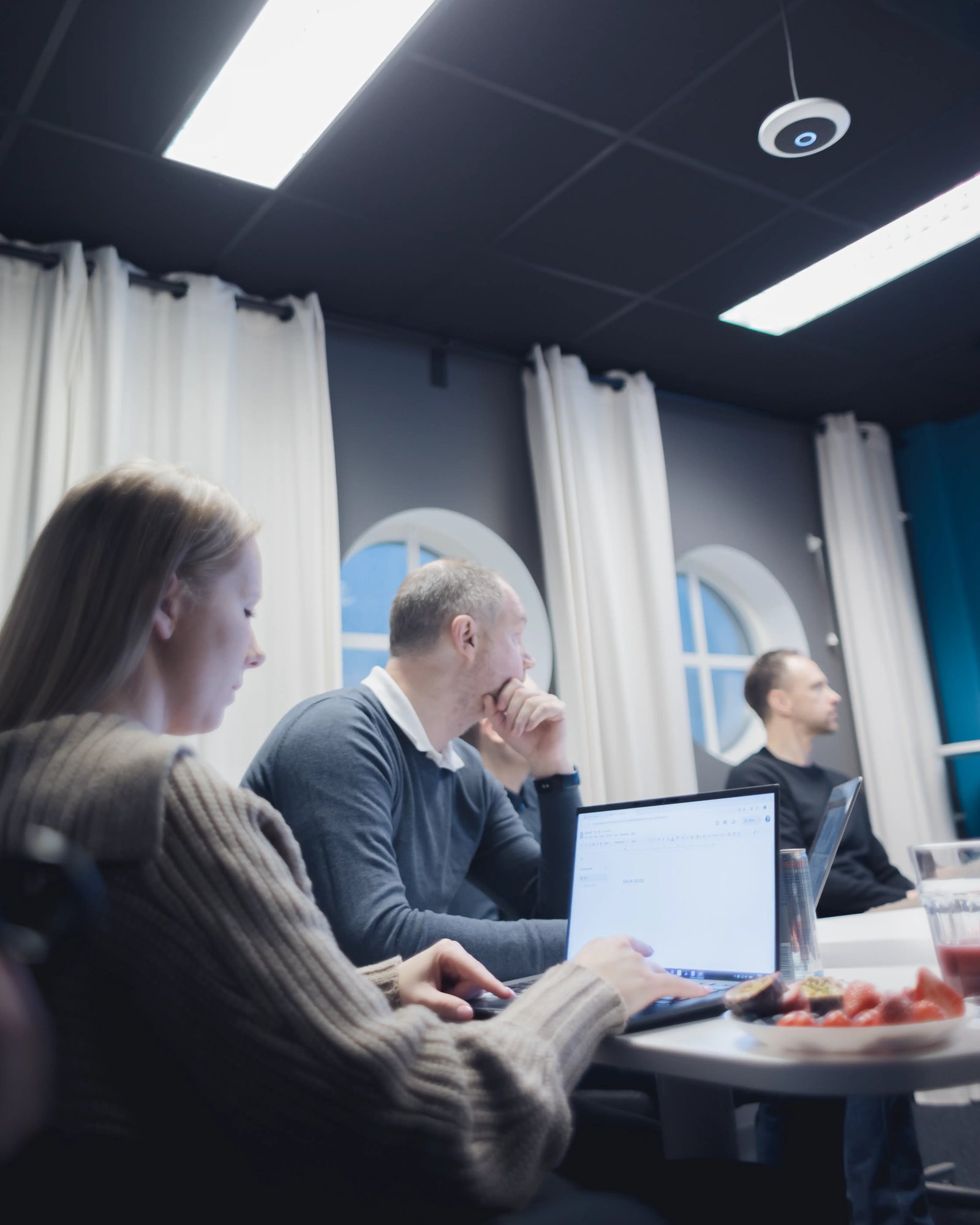 A picture of Madeleine, Johnny and William sitting in a meeting at the TeQflo office