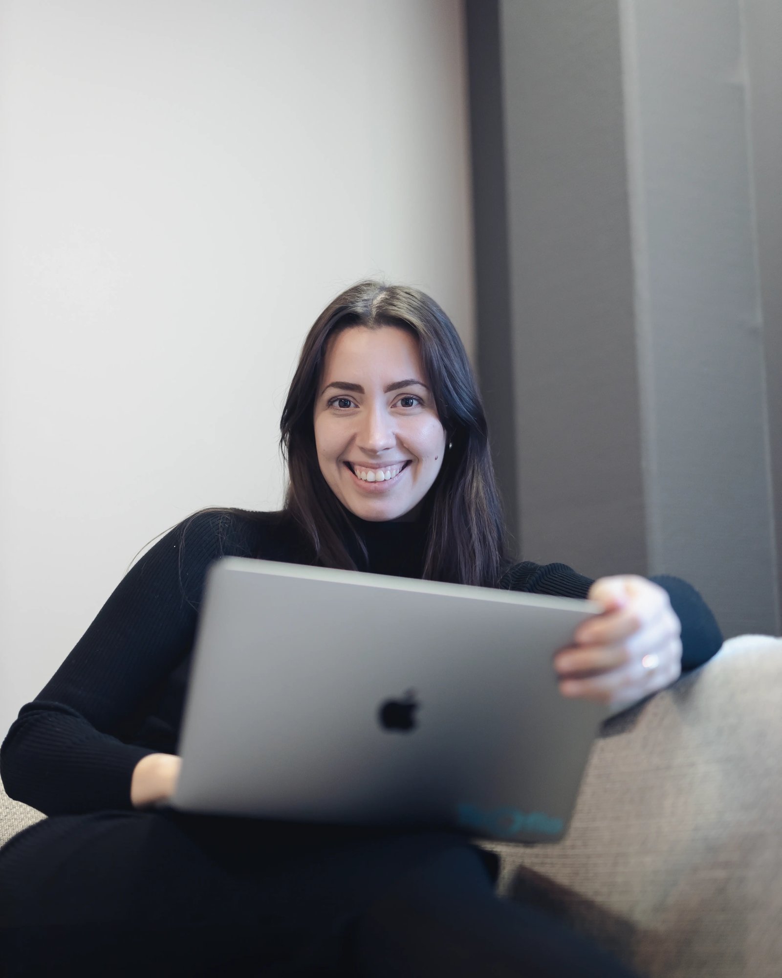 A picture of maia with a laptop on her lap in the TeQflo office
